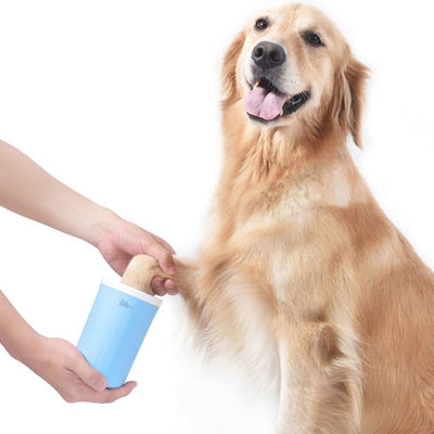 A Golden Retriever getting its paw cleaned with the Potty Buddy paw cleaner